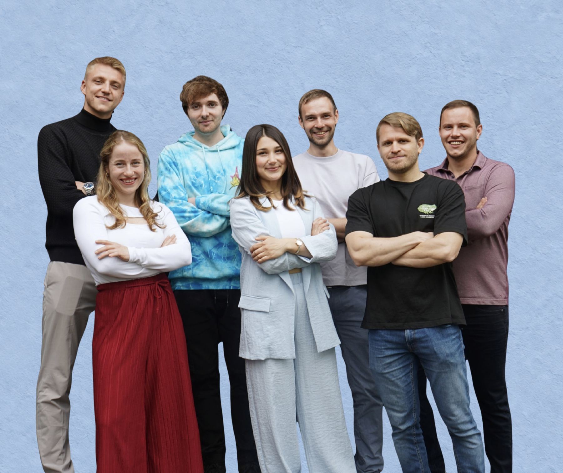Die sieben Mitglieder des mdp-Büroteams stehen lächelnd, die meisten mit verschränkten Armen, vor einer hellblauen Wand.
